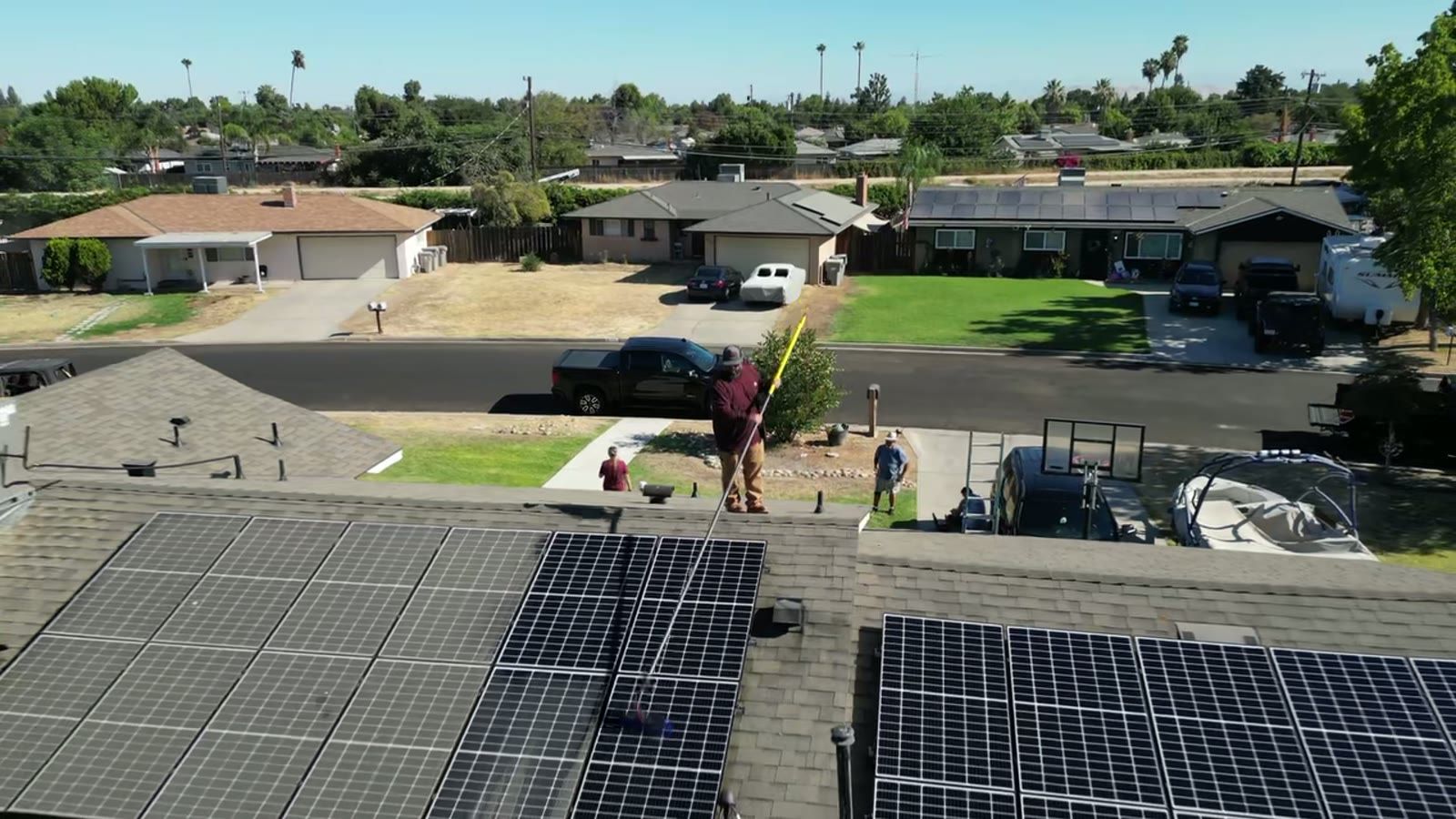 Matthew cleaning a rooftop solar array on a Central Valley home